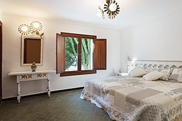 A bedroom with a large bed and a mirror