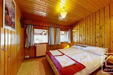 A bedroom with a bed and a poster on the wall that says alpine-pr