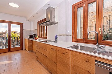 A kitchen with wooden cabinets and a stainless steel sink