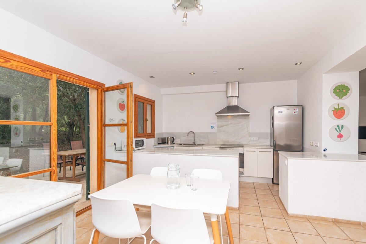 A kitchen with a refrigerator and a table and chairs