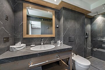 A bathroom with a toilet a sink and a mirror