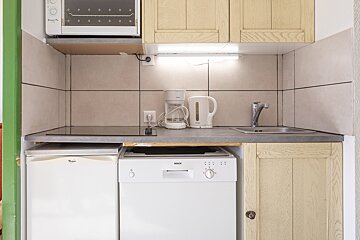 A kitchen with a bosch dishwasher and a whirlpool refrigerator