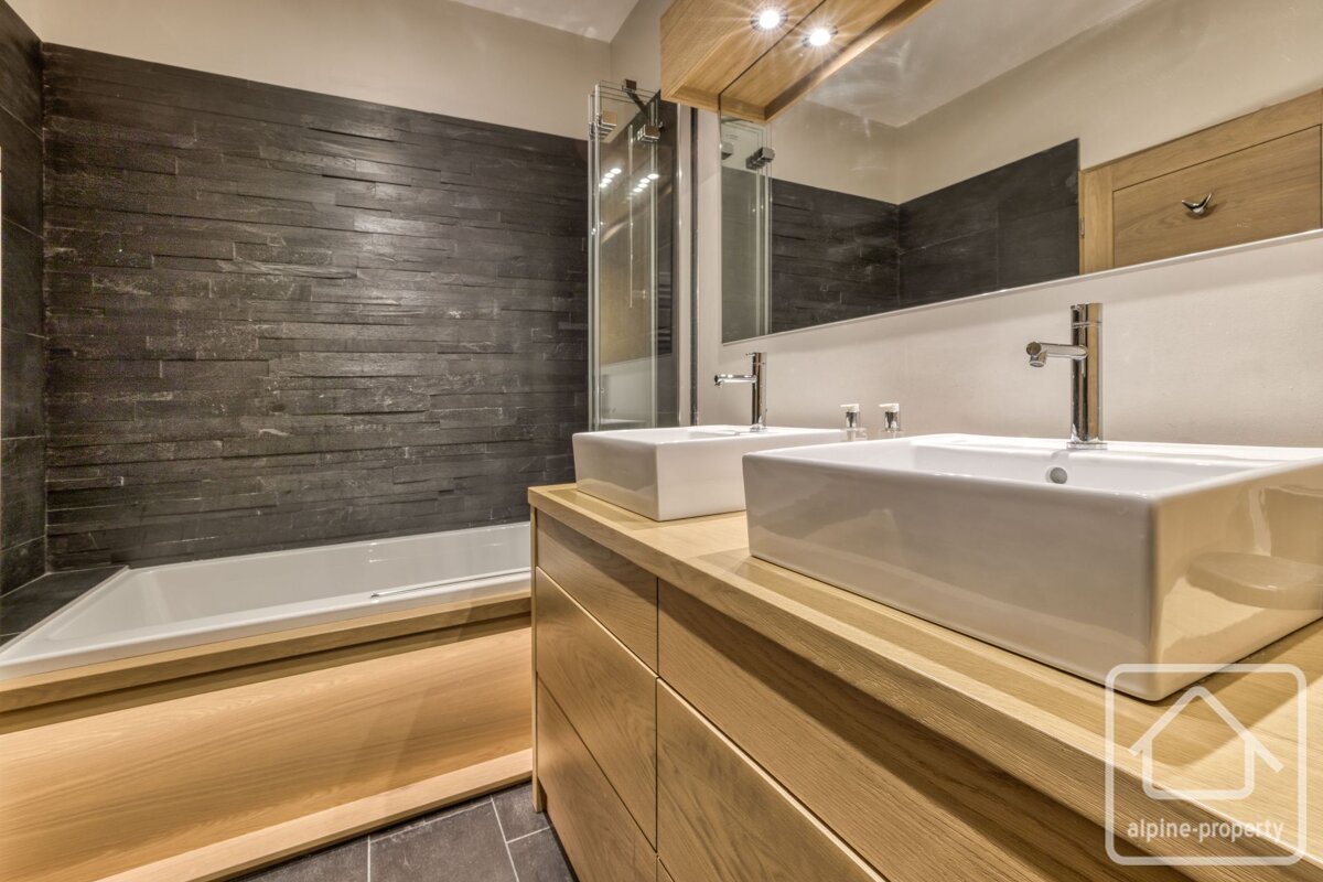 A bathroom with two sinks and a sign that says alpine property