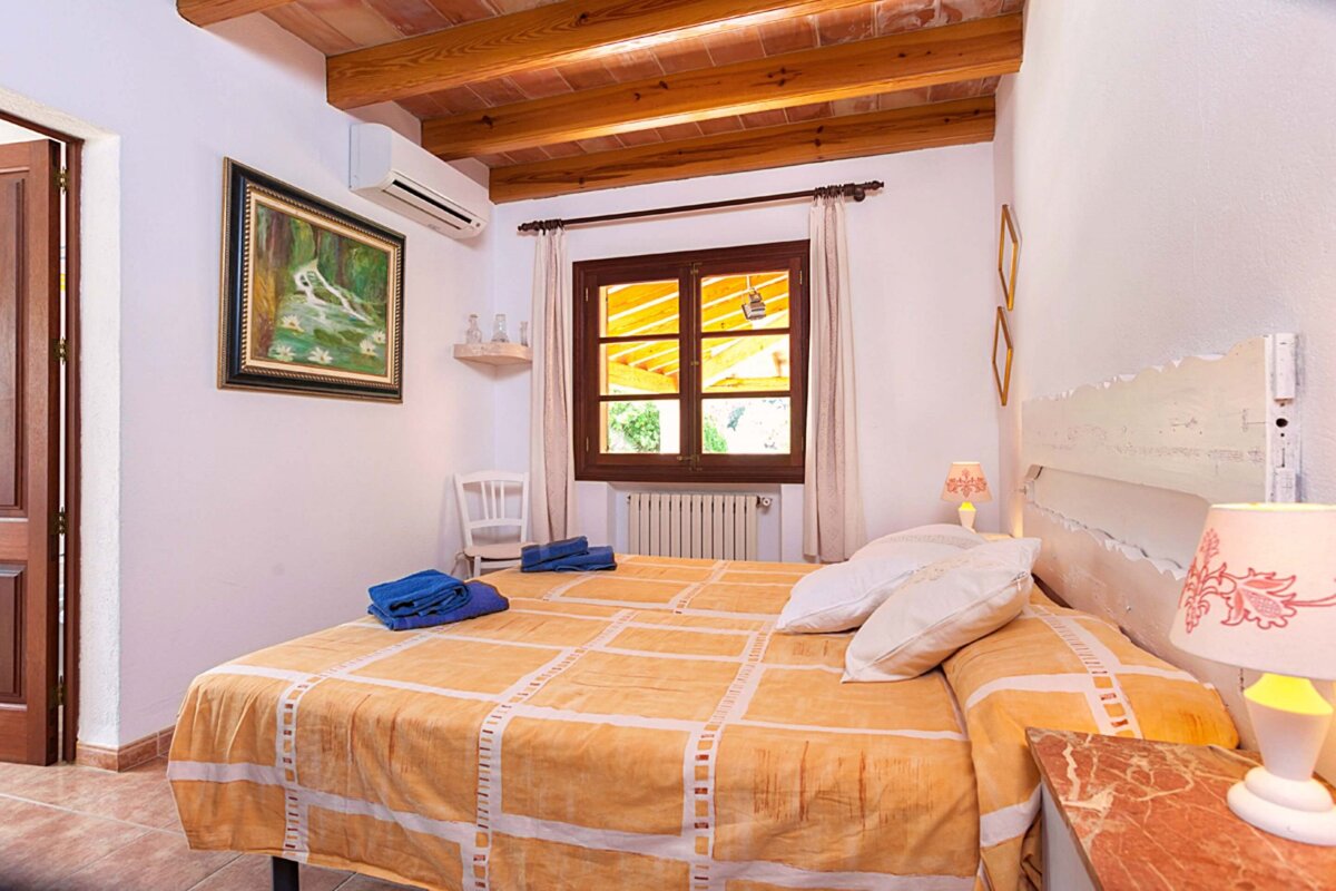 A bedroom with a bed and a painting on the wall