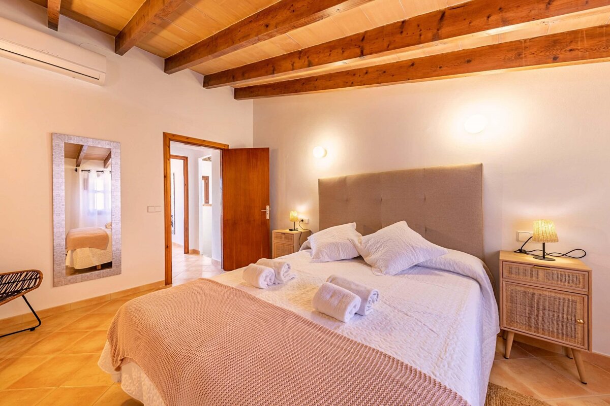 A bedroom with a large bed and a mirror