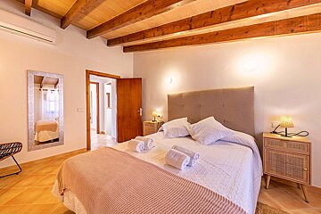 A bedroom with a large bed and a mirror