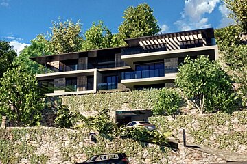 A modern multi-story villa built into a steep, stone-walled hillside covered in lush green foliage.
