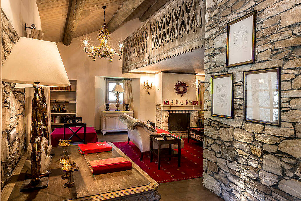 A living room with a stone wall and a fireplace