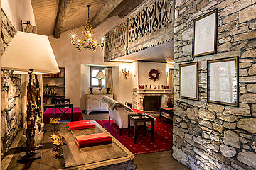 A living room with a stone wall and a fireplace