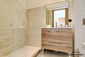 A bathroom with a rental designer logo on the wall