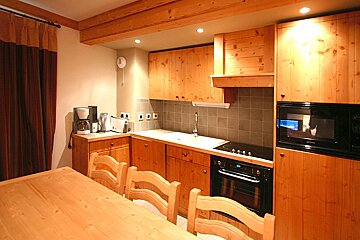 A kitchen with wooden cabinets and a stove top oven