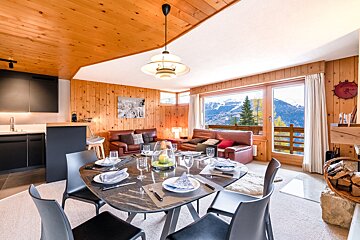 A living room with a dining table and chairs
