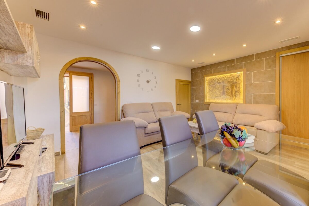 A living room with a clock on the wall that has the hands on the numbers 1 through 12