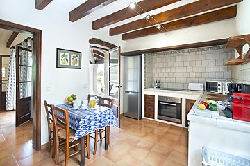 A kitchen with a table and chairs and a picture on the wall