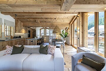 A living room with a white couch and green pillows