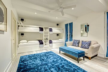 A bedroom with bunk beds and a blue rug