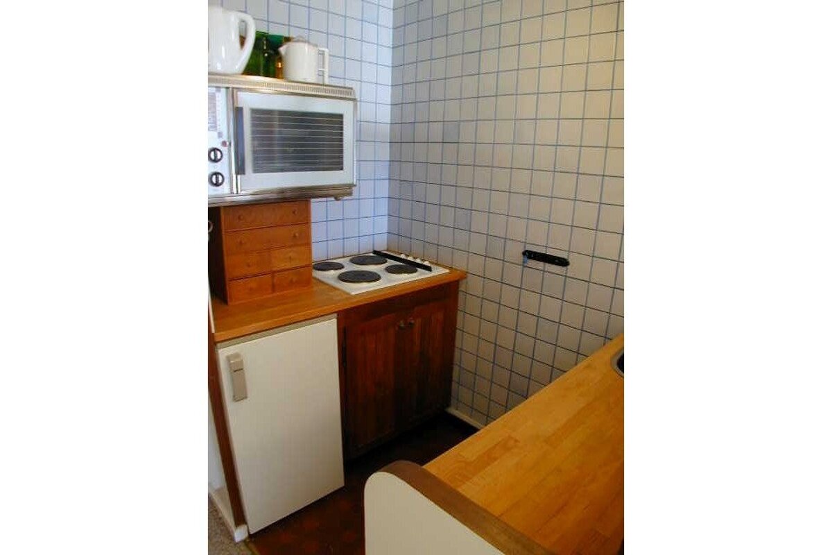 A small kitchen with a stove top oven and a microwave