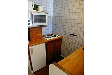 A small kitchen with a stove top oven and a microwave