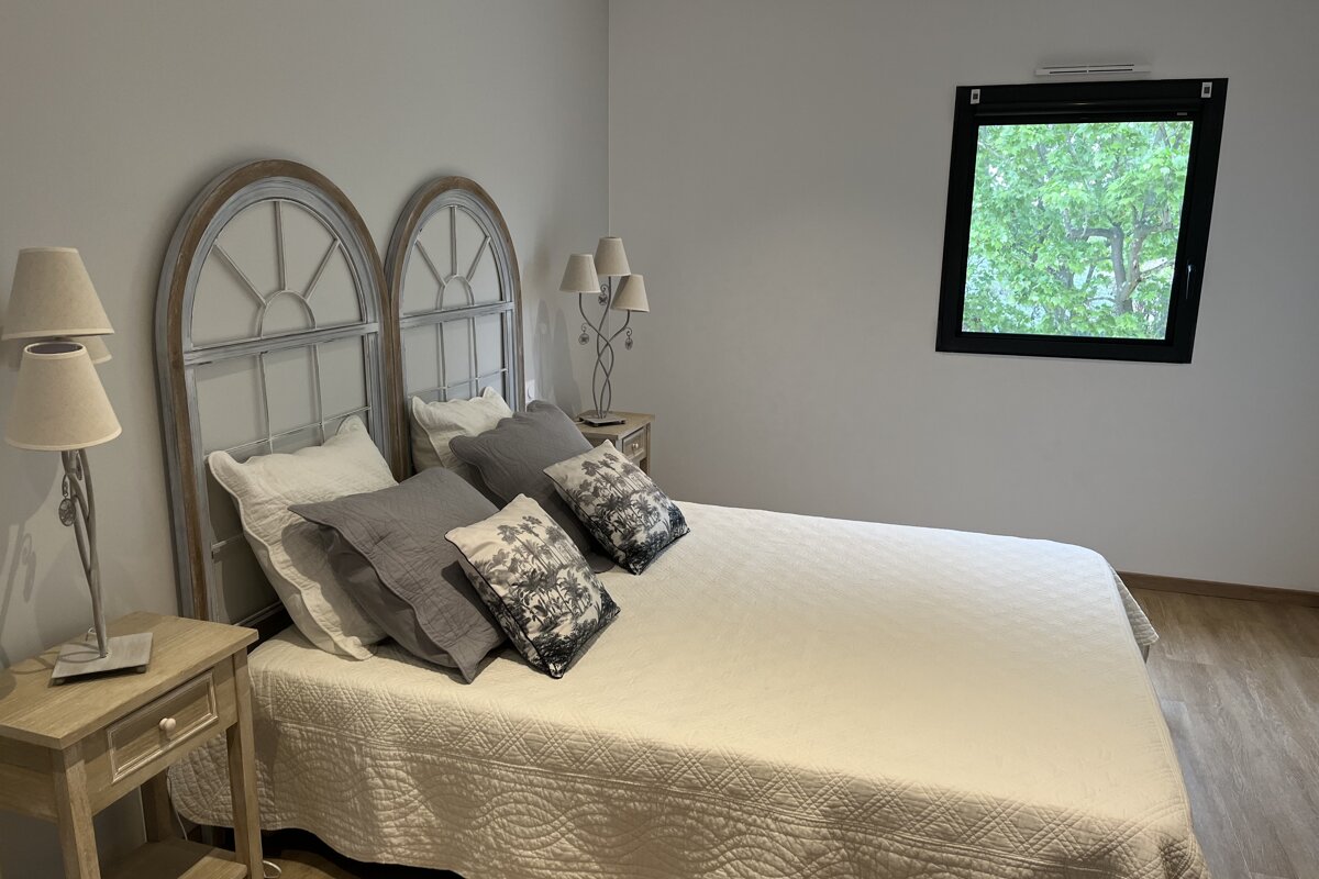 A bedroom with a large bed and a window