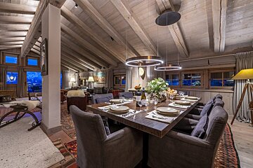 A dining room table with a bottle of wine on it