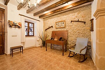 A rocking chair sits in a room with a stone wall
