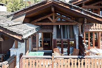 A wooden house with a roof that has shingles on it