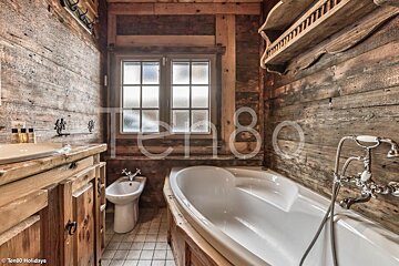 A bathroom with a bathtub and a bidet and a sign that says ten80 holidays