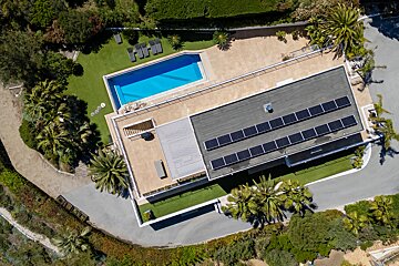 An aerial view of a house with solar panels on the roof