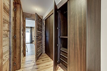 A hallway with a wooden door and a wooden cabinet