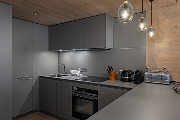 A kitchen with a toaster and a kettle on the counter