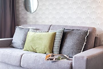 A couch with pillows and a magazine on it