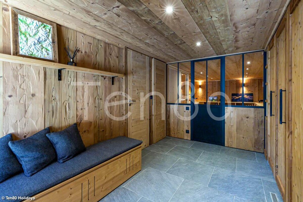 A wooden hallway with a bench and a sign that says tenda