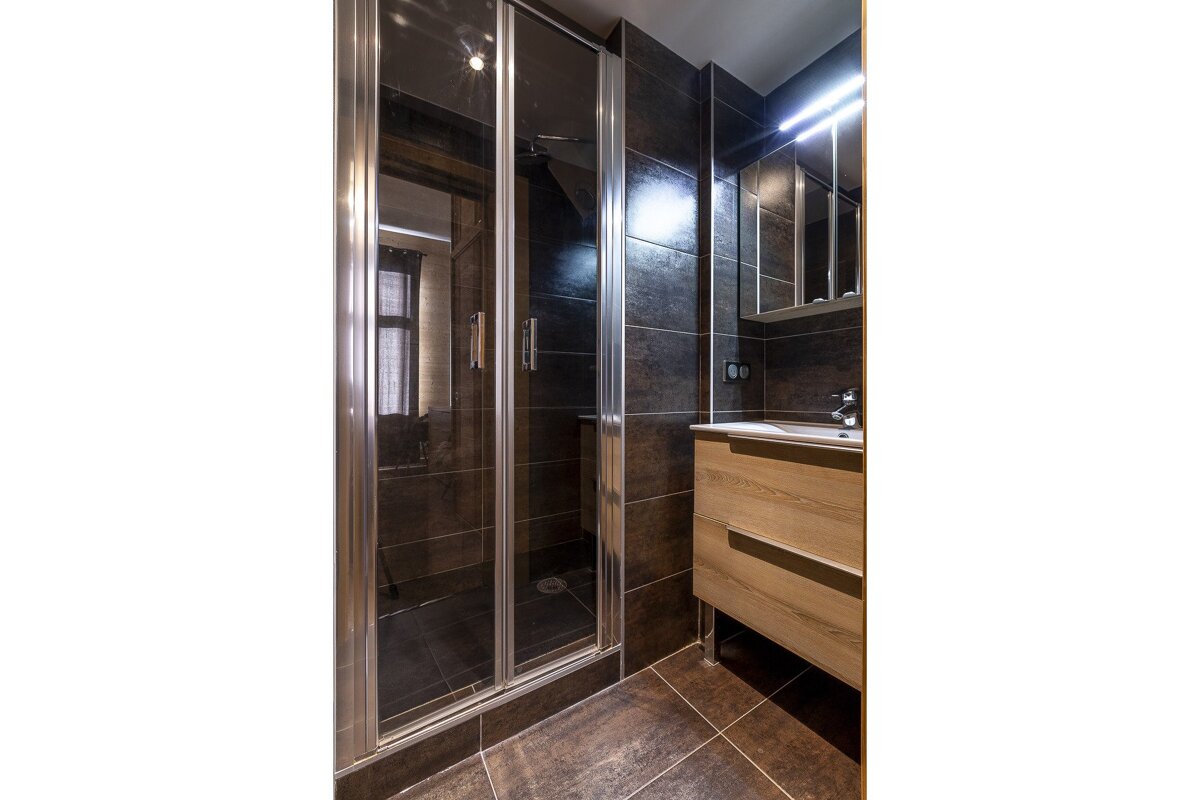 A bathroom with brown tiles and a bathtub