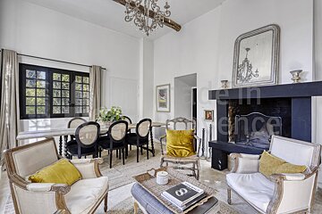 A living room with chairs and a fireplace with the word ence written on the wall