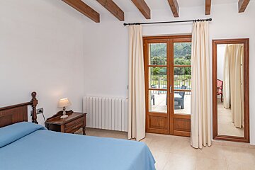 A bedroom with a blue bed and a mirror