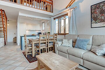 A living room with a couch a table and chairs