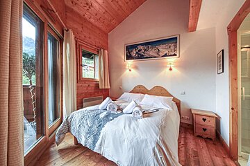 A bedroom with a bed and a picture on the wall