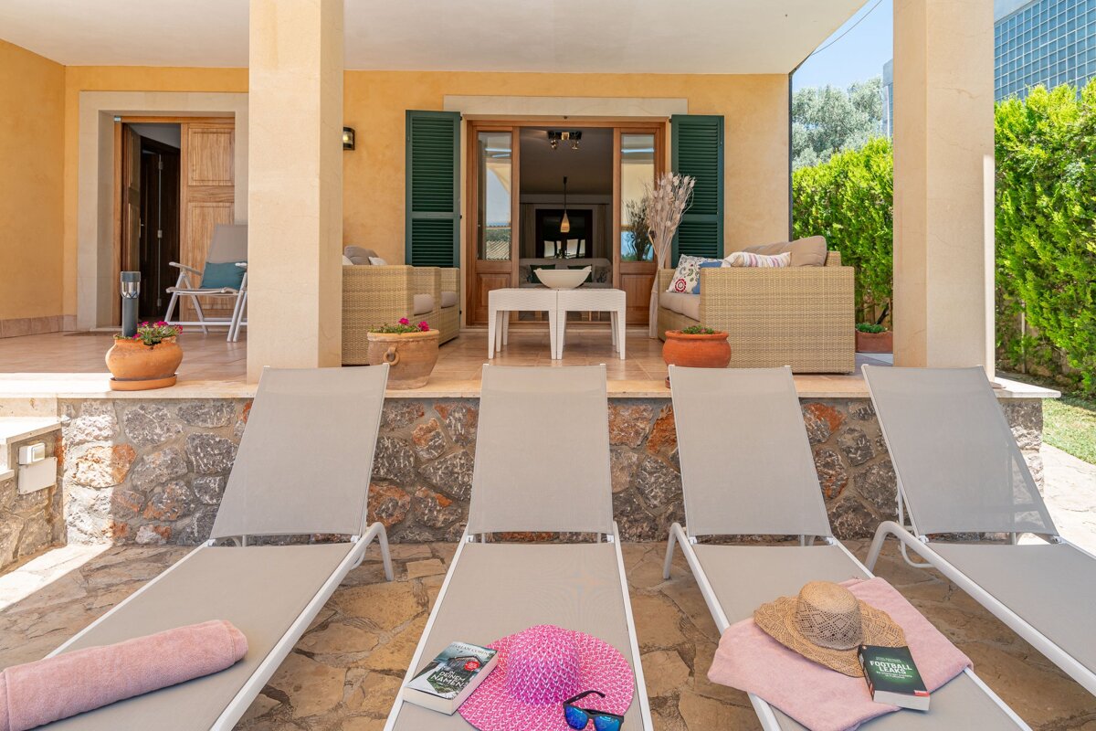 A row of lounge chairs with a hat and sunglasses on them