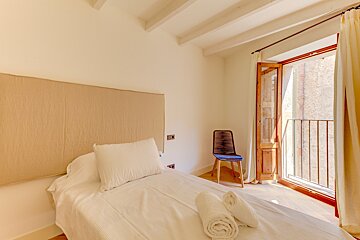 A bedroom with a single bed and a chair