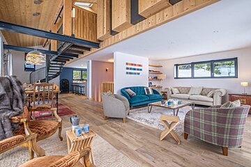 A living room with a blue couch and plaid chairs