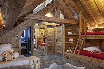 A wooden room with bunk beds and a ladder