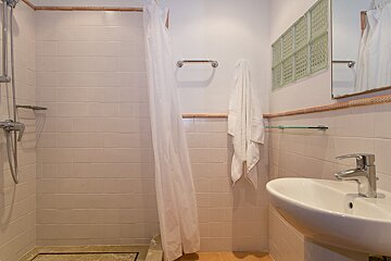 A bathroom with a sink and a shower with a white curtain