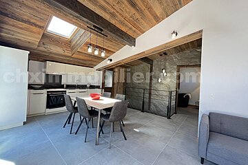 A kitchen with a table and chairs and a skylight above