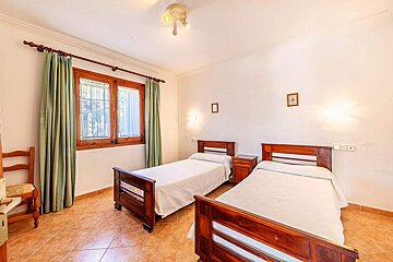 Two twin beds in a bedroom with green curtains