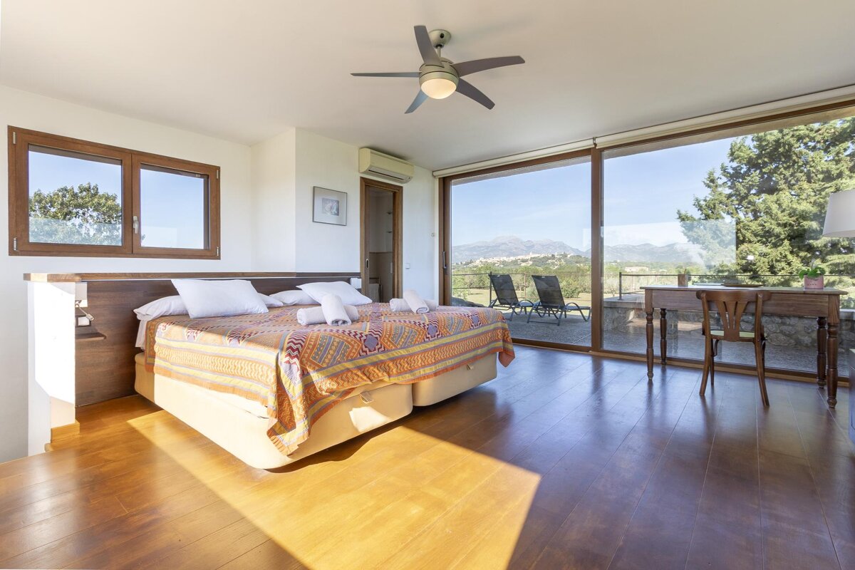 A bedroom with two beds and a ceiling fan