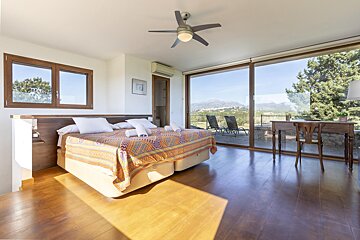 A bedroom with two beds and a ceiling fan