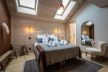 A bedroom with a large bed and a large mirror with the number 80 on it