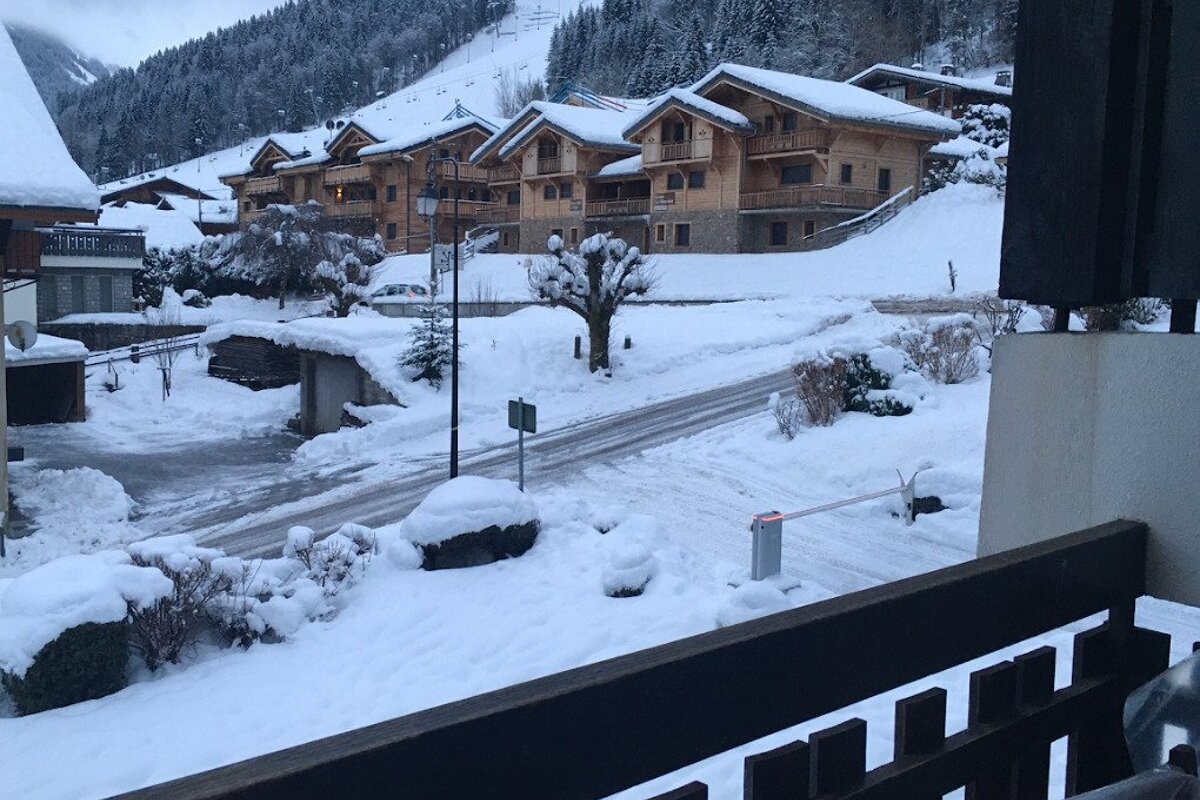 A snowy street with a sign that says no parking