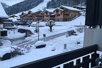 A snowy street with a sign that says no parking