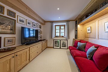 A living room with a red couch and a flat screen tv